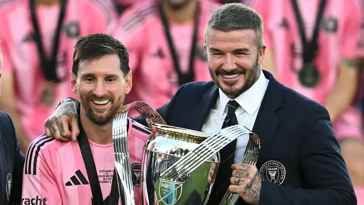 Lionel Messi and David Beckham holding trophy