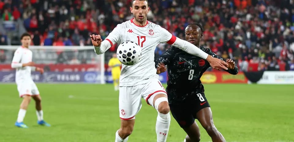 Tunisian player controls the ball against opponent