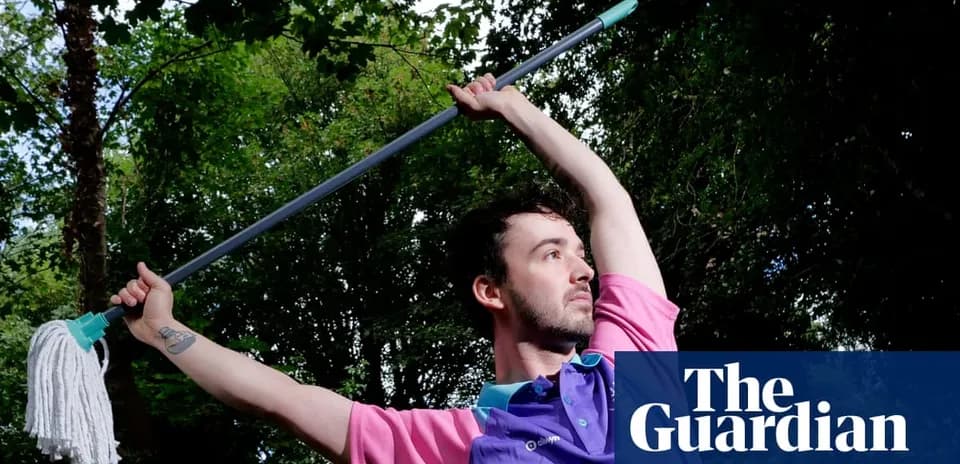 Man posing with a mop in outdoor setting