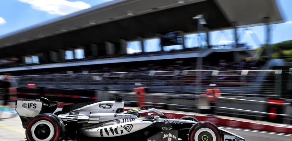 Formula 1 car racing past pit building during event