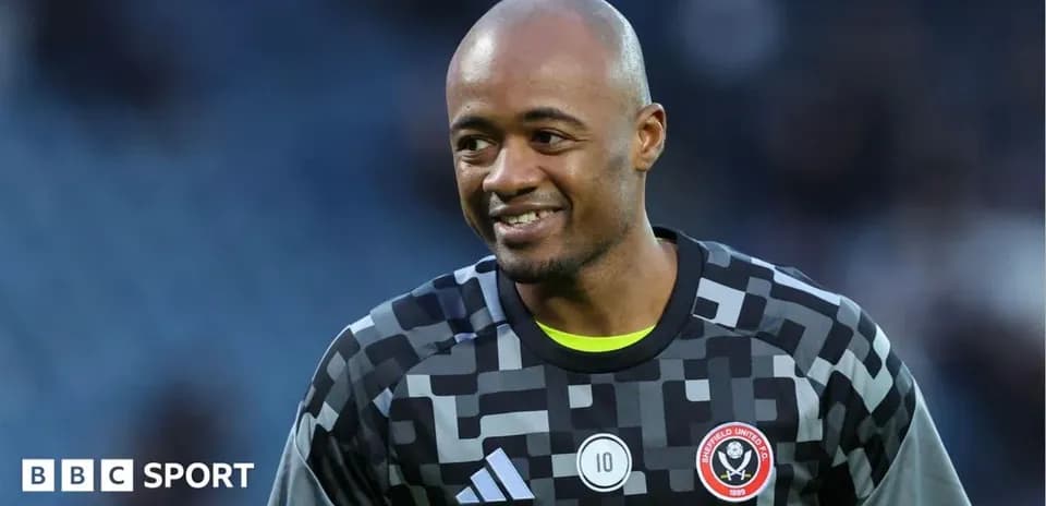 Goalkeeper in Sheffield United kit smiling on pitch