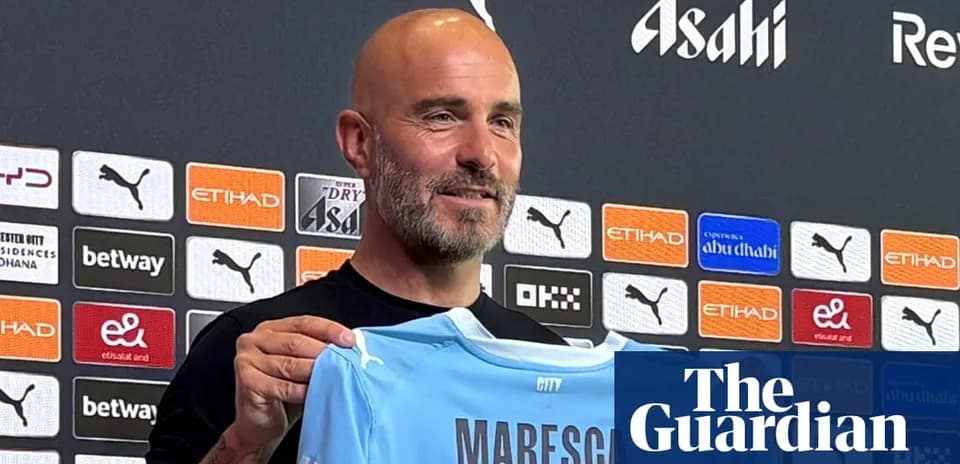 Yangi futbolchi formasini ushlab turgan murabbiy