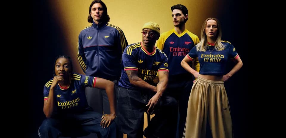 Five individuals wearing Arsenal jerseys posing together