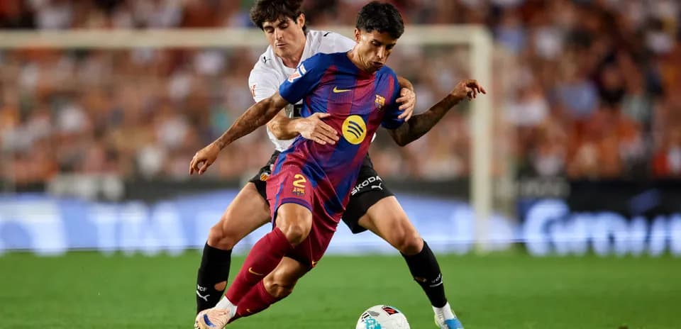 Barcelona player tackled by Valencia opponent during match