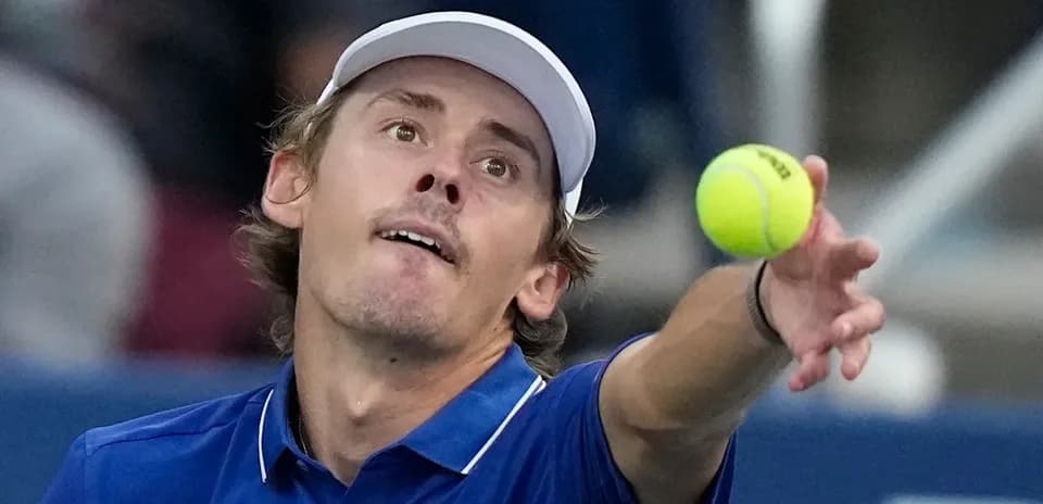Tennis player serving ball during match