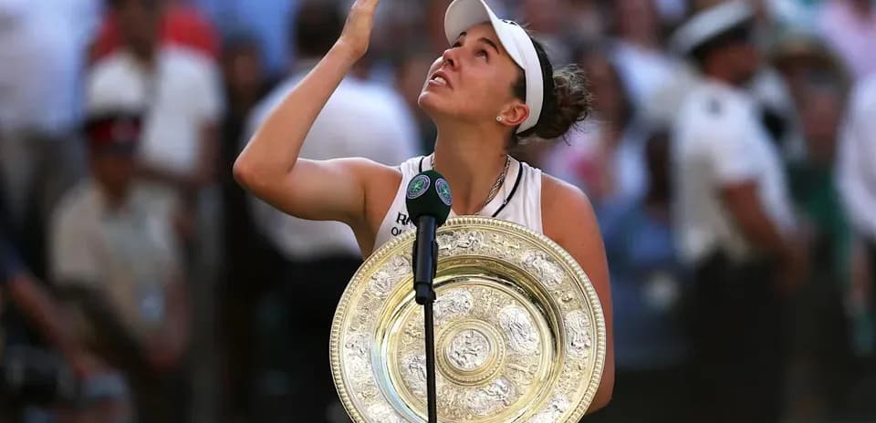 Tennis player holding Wimbledon trophy and looking up