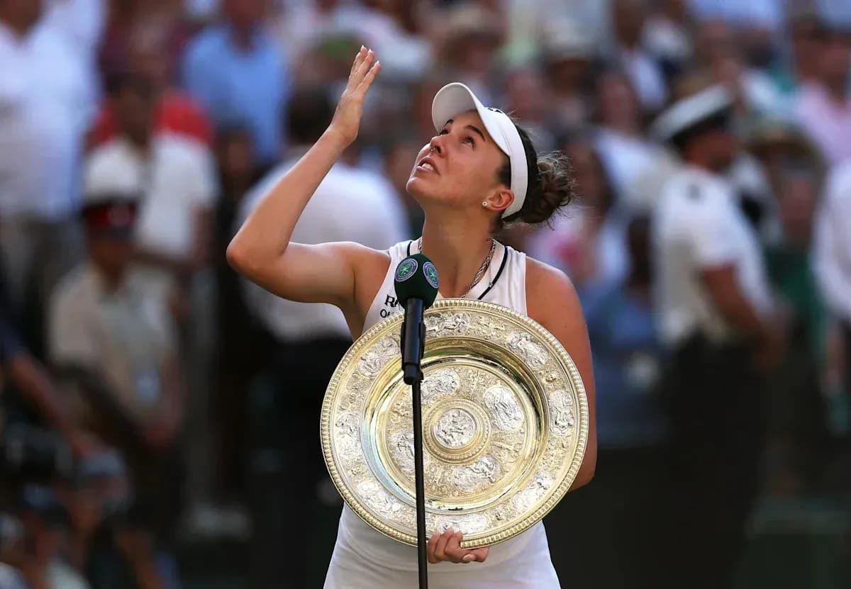 Tennis player holding Wimbledon trophy and looking up