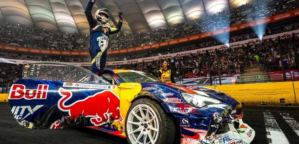 Driver celebrating on car after winning drift event