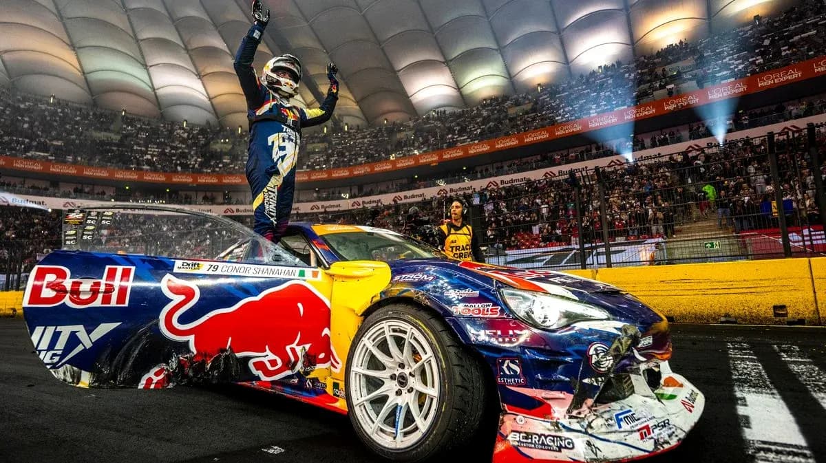 Driver celebrating on car after winning drift event
