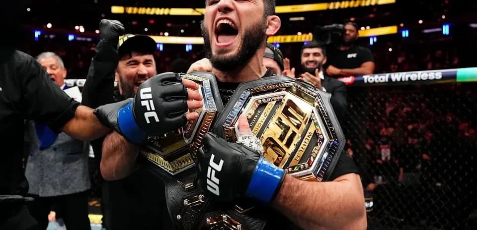 Fighter celebrating with championship belts after victory