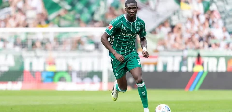 Futbolchi maydonda to'p bilan harakatda