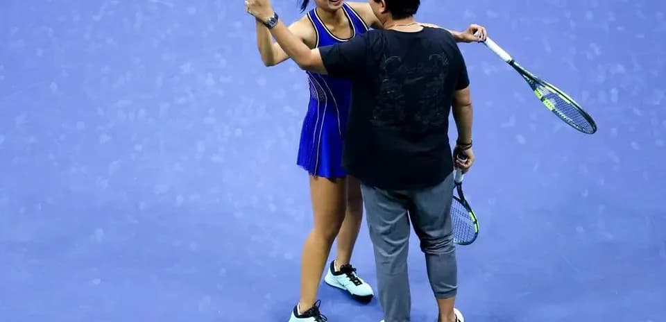 Tennis player celebrating with coach on court