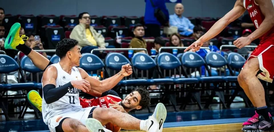 Two players on the floor battling for the ball