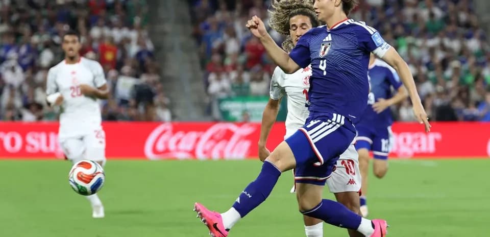 Japan player kicking ball during match against Tunisia