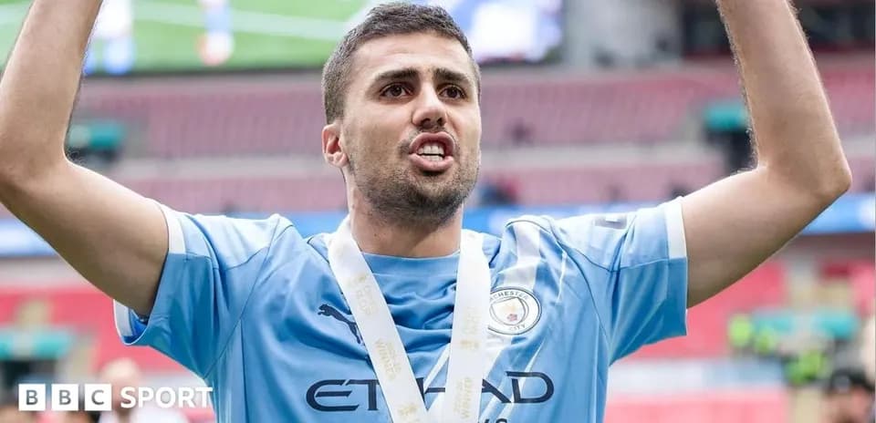 Futbolchi qo'lida medali bilan g'alaba nishonlamoqda