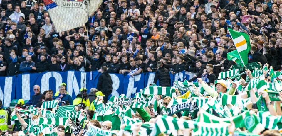 Celtic fans waving scarves at football match