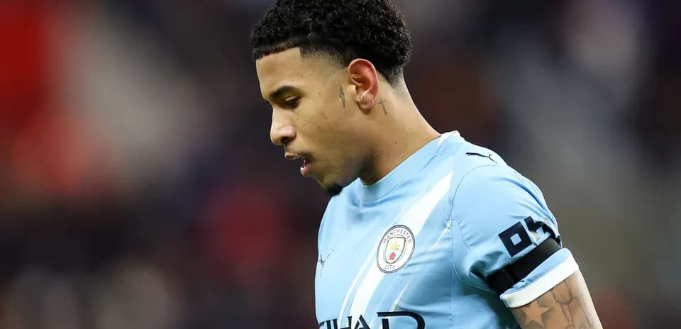 Futbolchi Manchester City formasida, pastga qarab turibdi