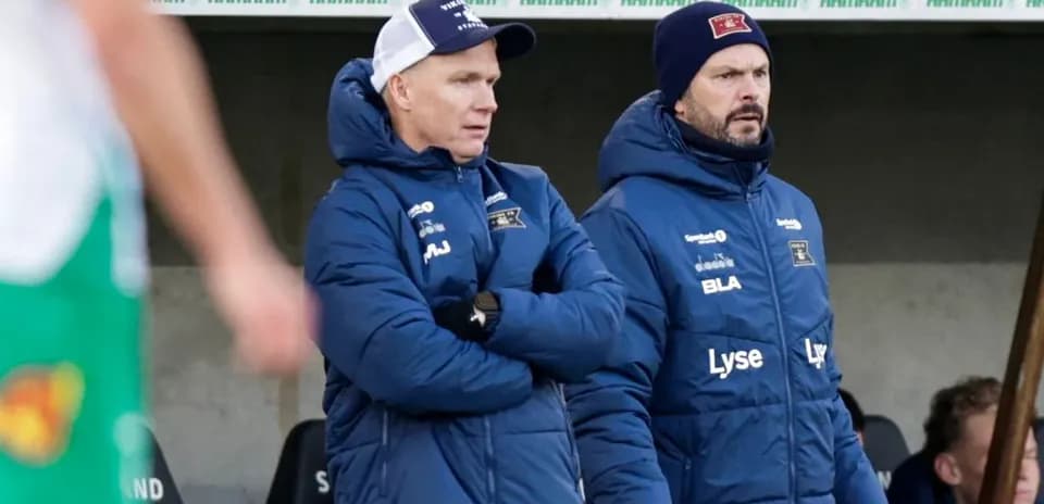 Two coaches observing the match from the sidelines