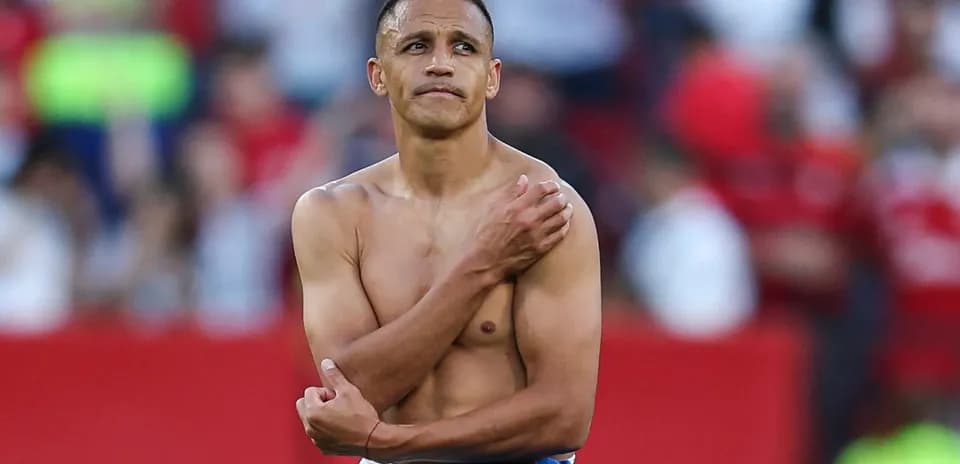 Futbolchi maydonda ko'ylaksiz, qo'lini ko'tarib turibdi