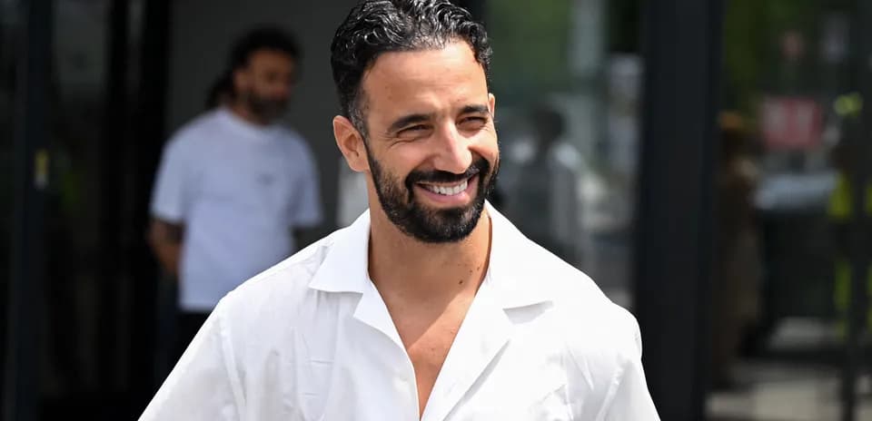 Shirtless man smiling in a white shirt