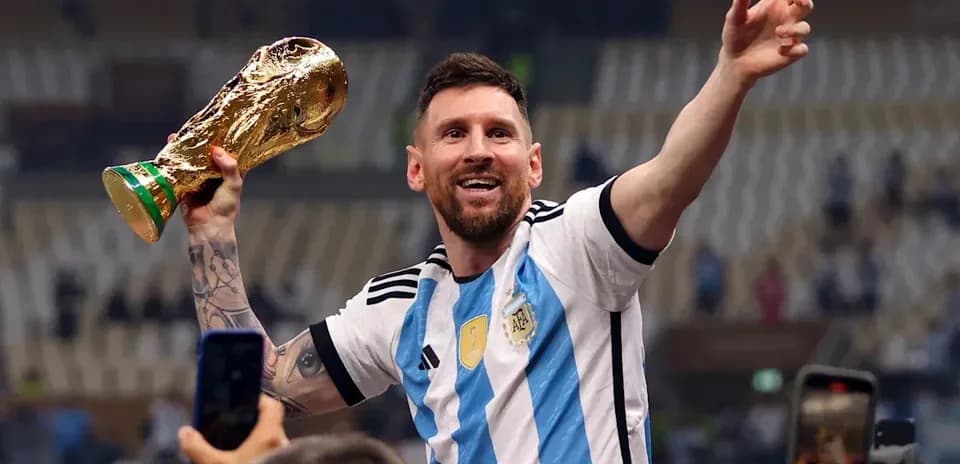 Futbolchi Messi Kubokni ko'tarib turib, nishonlaydi
