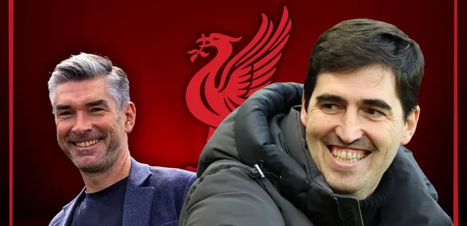 Two coaches smiling with Liverpool logo background