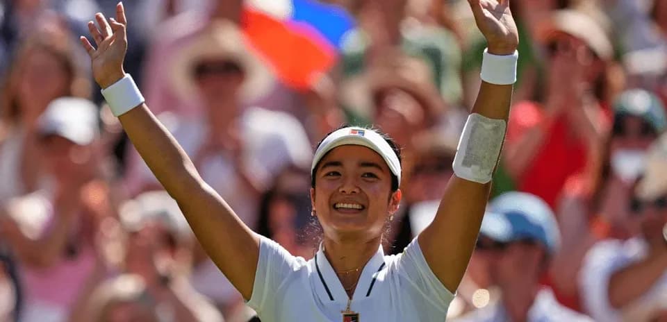 Tennis player celebrating with arms raised in crowd