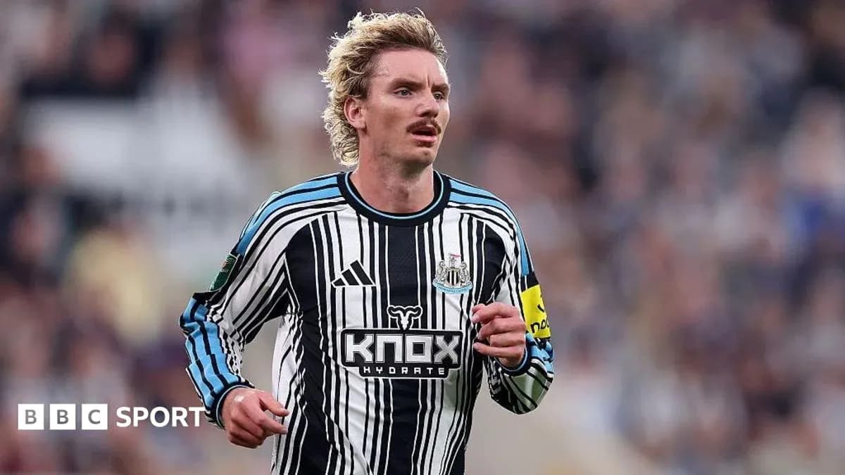Futbolchi Newcastle formasida maydonda yugurmoqda