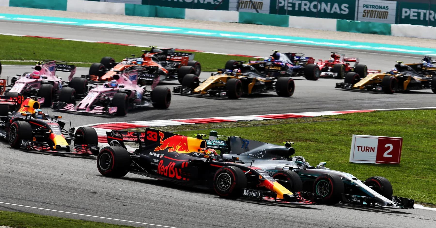 Formula 1 cars racing at Turn 2 of circuit
