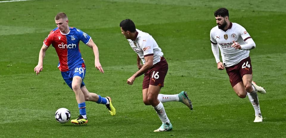 Crystal Palace player running with the ball, two defenders chasing