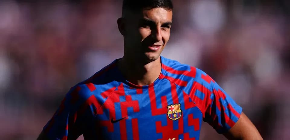Futbolchi Barcelona formasini kiygan yigit kulmoqda