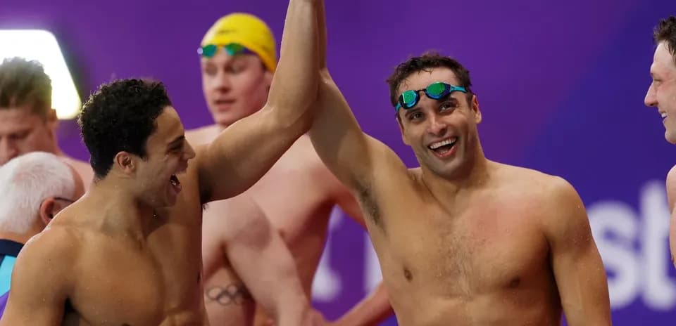 Two swimmers celebrating together after competition