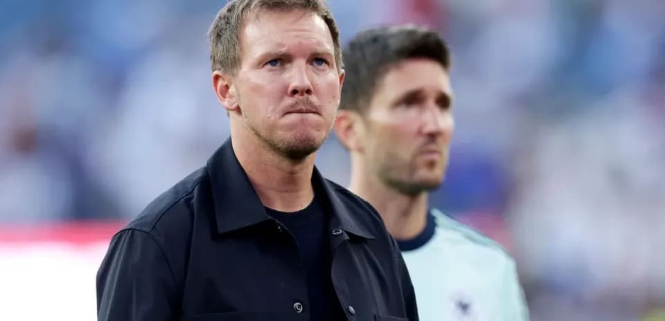 Two coaches standing on the sidelines before match