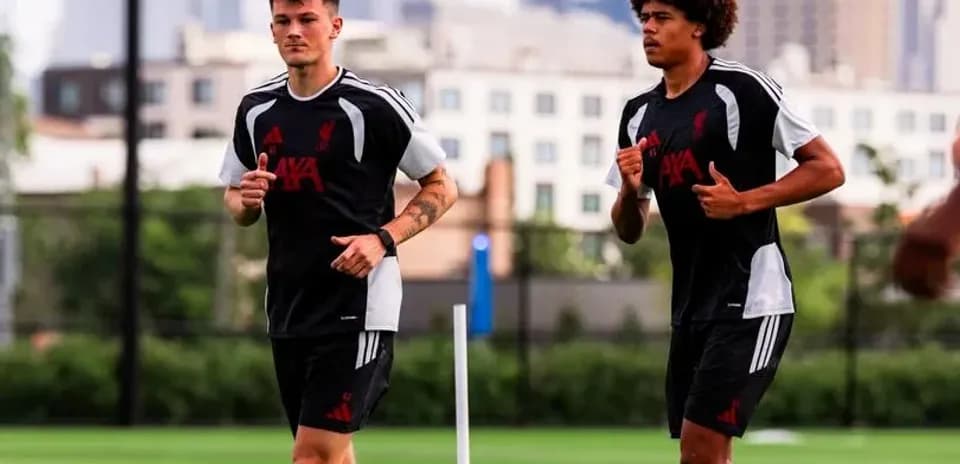 Ikkita futbolchi trening maydonida yugurmoqda