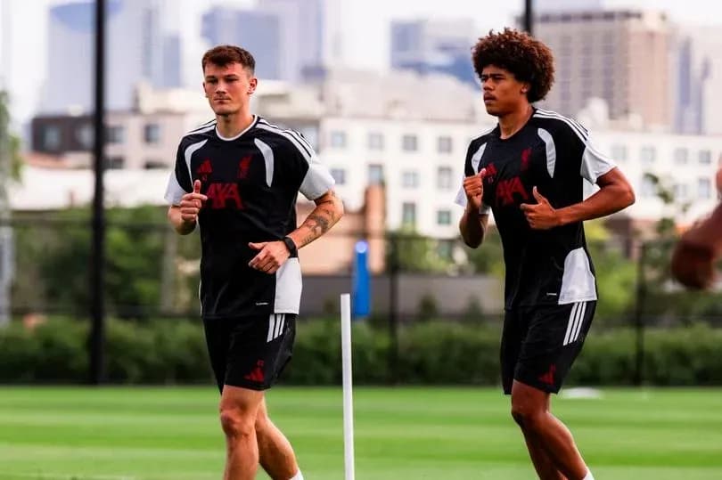 Ikkita futbolchi trening maydonida yugurmoqda