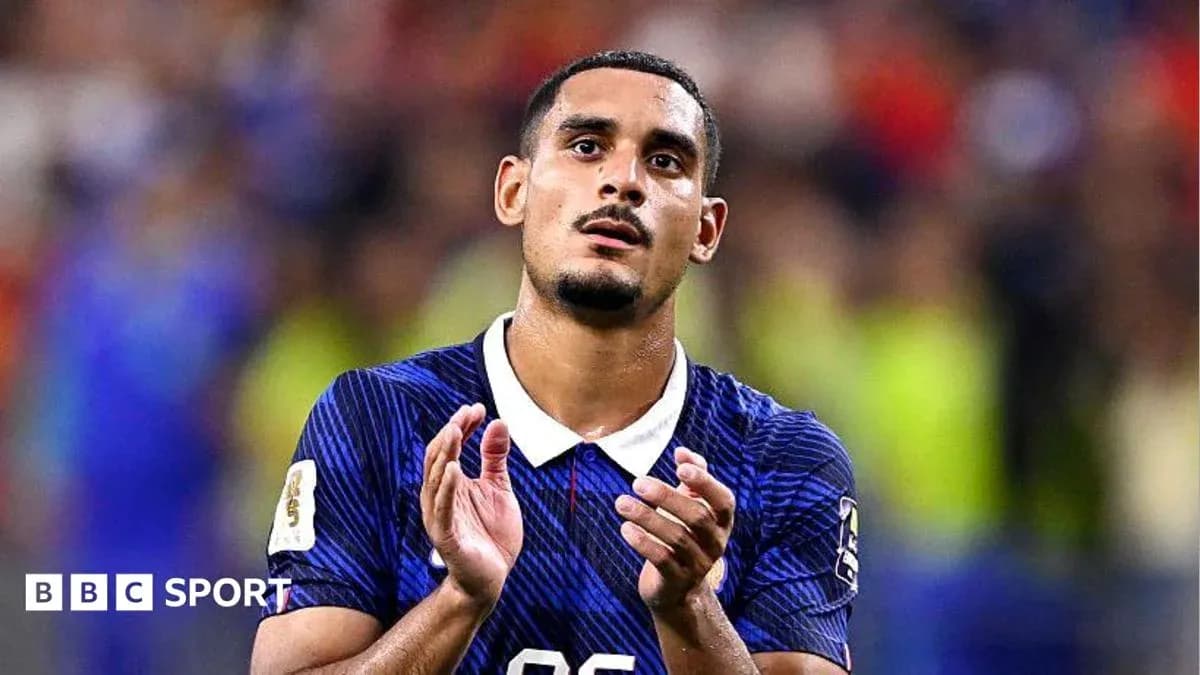 Futbolchi maydonda qo'llarini ko'tarib turgan