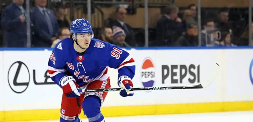 Hockey player skating with puck during match