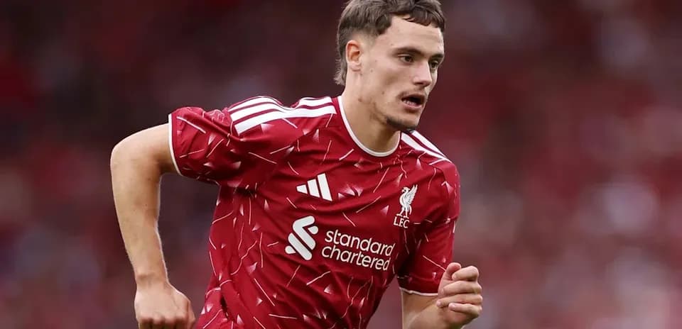 Futbolchi Liverpool formasida maydonda yugurmoqda