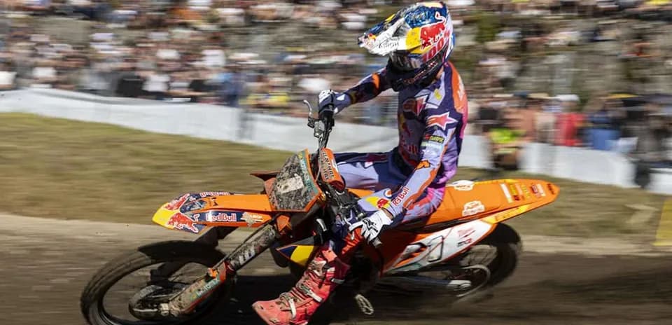 Motocross rider navigating a dirt track at event