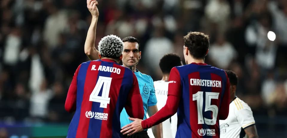 Referee showing yellow card to Barcelona player