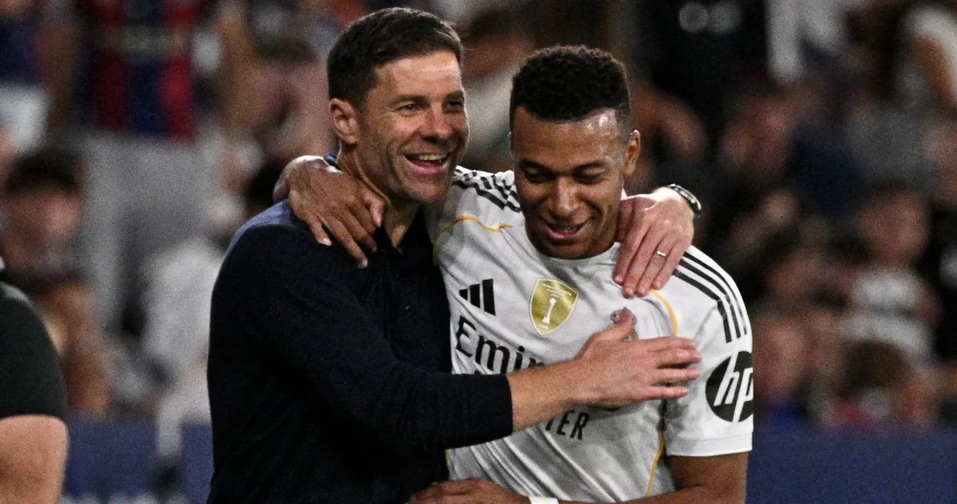Trener va o'yinchi quchoqlashmoqda, stadionda
