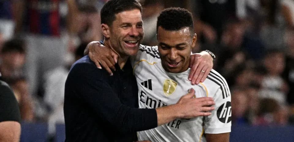 Trener va o'yinchi quchoqlashmoqda, stadionda