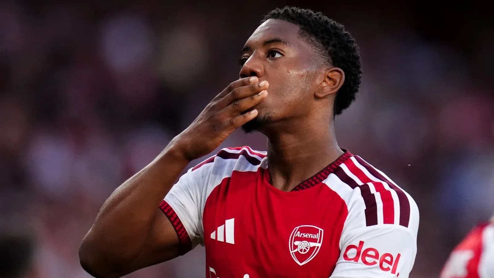 Futbolchi Arsenal formasida gol urish holatida