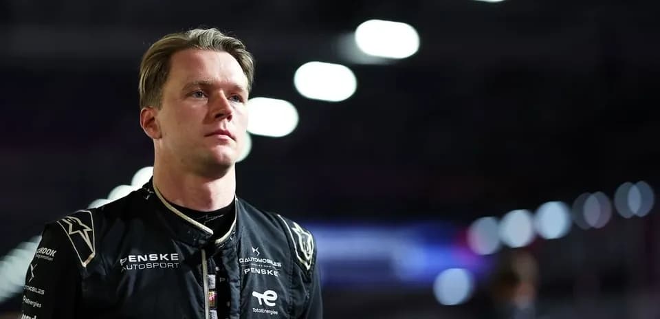 Pilot in racing suit standing under bright lights