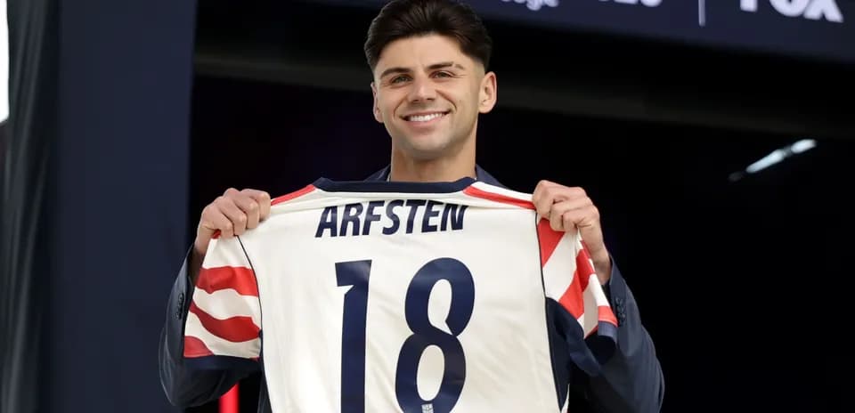 O'yinchi ARFSTEN 18 raqamli futbolka ushlab turibdi