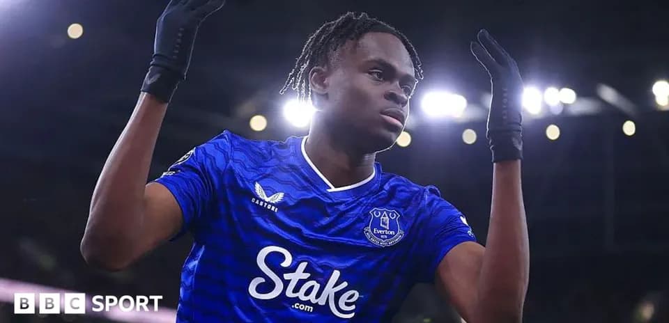 Futbolchi Everton formasida, qo'llarini ko'tarib turibdi