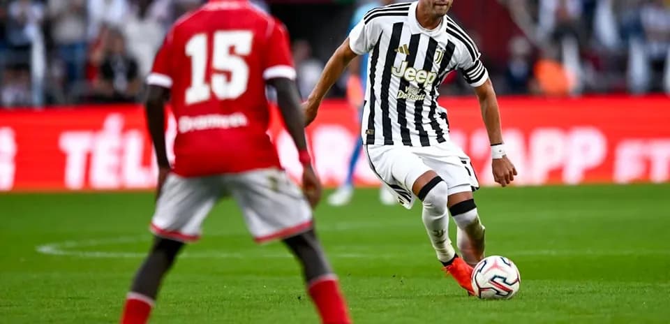Juventus player dribbling past opponent during match
