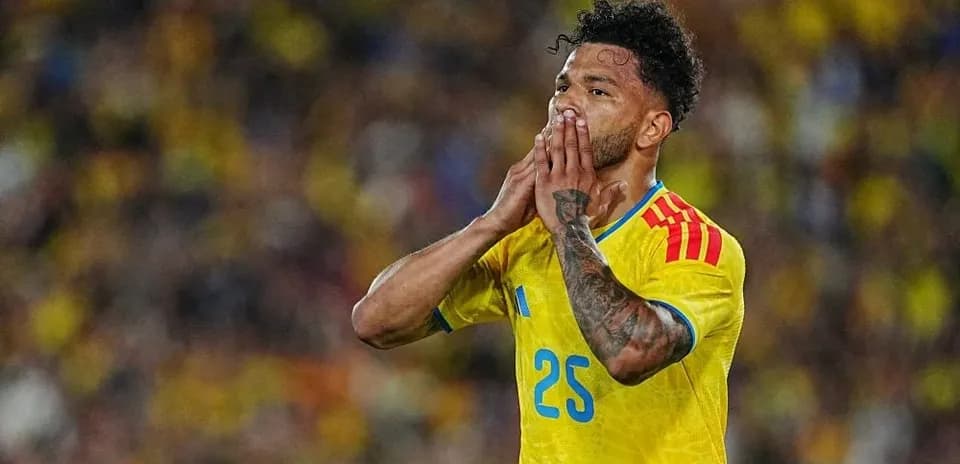 Futbolchi raqibga qarab qo'llarini ko'targan