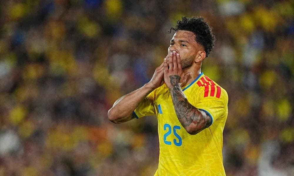 Futbolchi raqibga qarab qo'llarini ko'targan