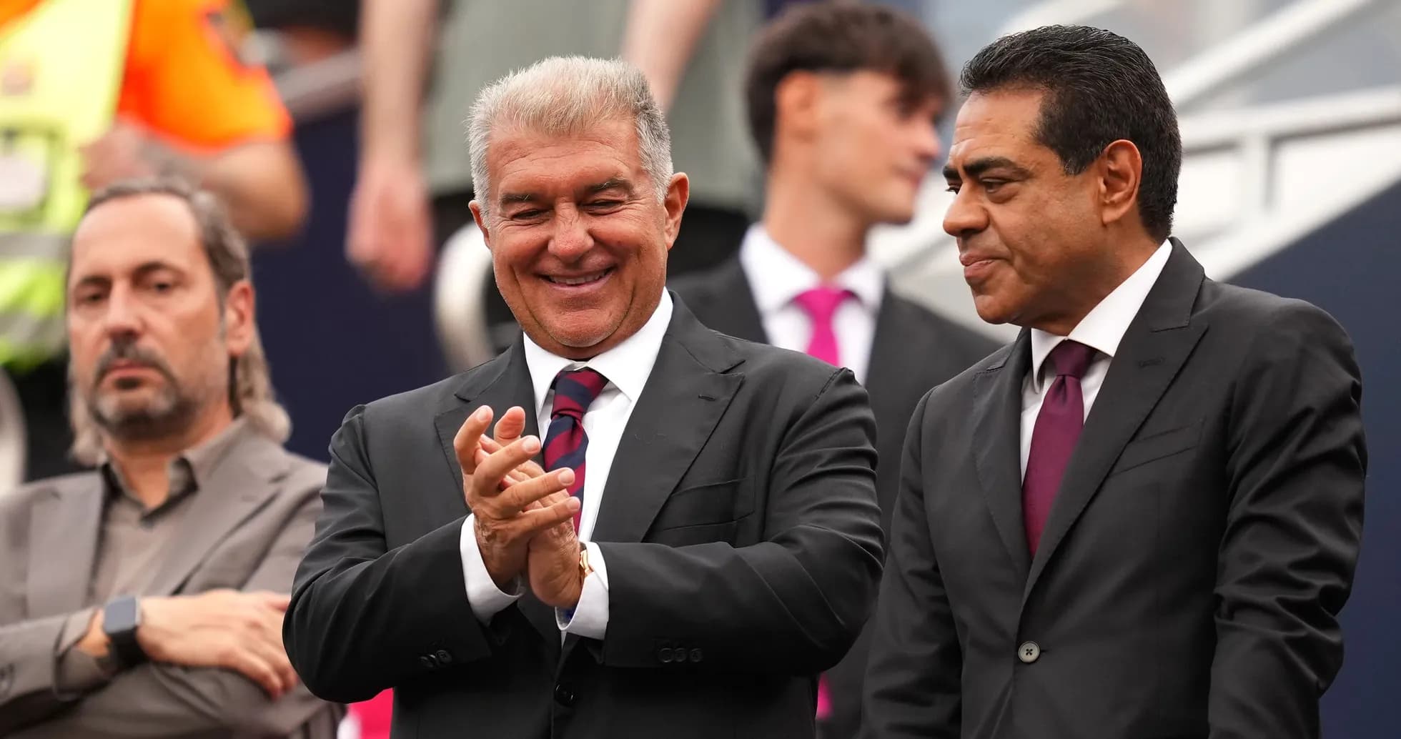 Three men in suits observing an event